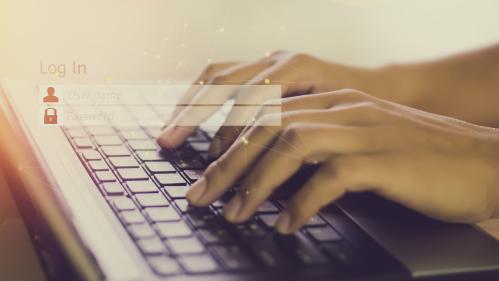 a pair of hands typing on a laptop keyboard
