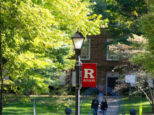  An R logo banner hangs on a lamppost outside Old Queens on the College Ave campus